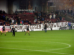 Transparent mit der Aufschrift "Gemeinsam gegen Terminwillkür" vor der alten Haupttribüne vom Millerntor-Stadion, November 2001