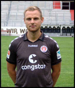 Portraitfoto von Bernd Nehrig, ehemaliger Spieler vom FC St. Pauli, vor einer Tribüne im Millerntor-Stadion